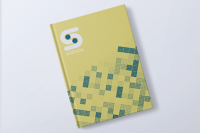 Un'agenda cartonata giornaliera chiusa con copertina giallo vivace, motivo mosaico pixel teal e logo 'S' bianco. Ideale per aziende, agenzie e professionisti che cercano agende cartonate giornaliere personalizzate (1 giorno per pagina, 2 formati, layout completamente personalizzabile) per rafforzare l'identità di brand e fare un'impressione distintiva.