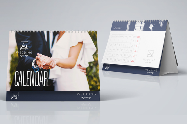 Calendari da scrivania personalizzati con rilegatura a spirale professionale e qualità di stampa premium, perfetti per matrimoni, branding aziendale o regali ai clienti. Il design presenta un elegante schema di colori blu navy con spaziose pagine di calendario per la pianificazione mensile. Stampa calendari da scrivania personalizzati per mantenere il tuo marchio visibile e raccontare la tua stor…