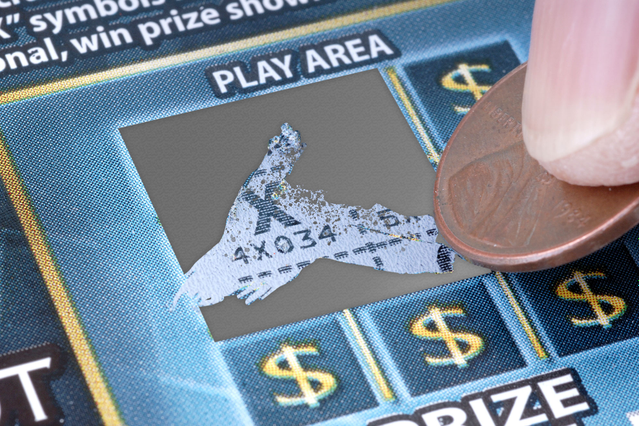 Un gratta e vinci personalizzato con la patina argentata rimossa da una moneta che rivela un simbolo di premio vincente nell'area di gioco. Sprint24 stampa gratta e vinci personalizzati con numerazione progressiva, codici alfanumerici e barcode — ideali per campagne promozionali, concorsi, buoni regalo e direct marketing.