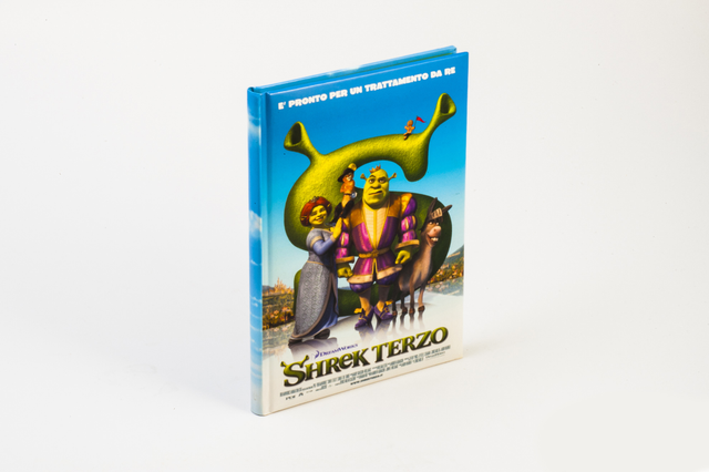 Un libro cartonato con copertina illustrata a colori del film animato 'Shrek Terzo' con i personaggi Shrek, Fiona e il ciuchino su sfondo bianco. I libri con copertina rigida e rilegatura a filo refe sono il formato ideale per libri per bambini, volumi illustrati e pubblicazioni che devono resistere a un uso intenso — durevoli, pregiati e completamente personalizzabili.