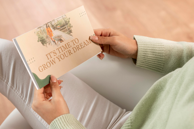 Una persona che tiene una cartolina personalizzata in formato orizzontale con il messaggio motivazionale 'It's Time to Grow Your Dreams' su una fotografia di giardino. Le cartoline personalizzate stampate in formato orizzontale sono uno strumento di marketing efficace per promuovere brand lifestyle, eventi wellness, garden center, servizi di coaching e lanci di prodotto.