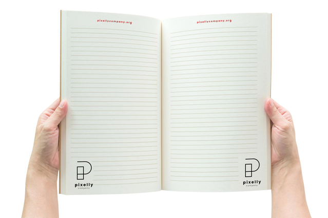 Mani tengono aperto quaderno brossura Pixelly Company a righe con logo e URL. Formati A4/A5 Sprint24.