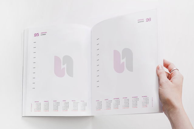 Mano con agenda filorefe giornaliera aperta filigrana logo U rosa e. Mano con agenda filorefe giornaliera aperta filigrana logo U rosa e mini-calendari. 336 pagine Sprint24.
