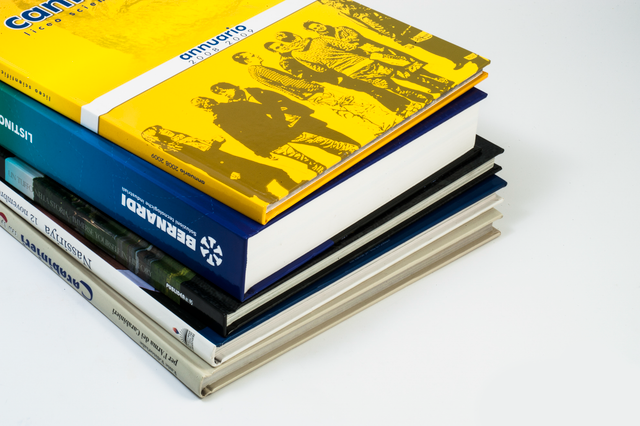 Libri cartonati di pregio con copertina rigida e design vari. Rilegatura di qualità per edizioni prestigiose e pubblicazioni di lusso. Lavorazione: verniciatura UV; filorefe e rilegatura cartonata; pellicatura.