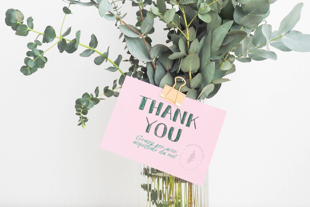 Una thank you card rosa con messaggio in stile manoscritto inserita in un bouquet di eucalipto fresco. Sprint24 stampa cartoline di ringraziamento personalizzate su carta Fedrigoni di alta qualità per impreziosire le spedizioni e fidelizzare i clienti — perfette per negozi online e attività di regalo.